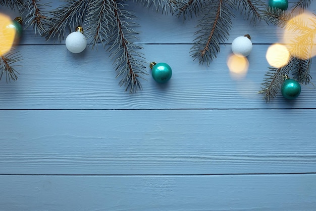 Kerstmis en Nieuwjaar houten achtergrond met blauwe dennenboom takken kerstspeelgoed en verlichting