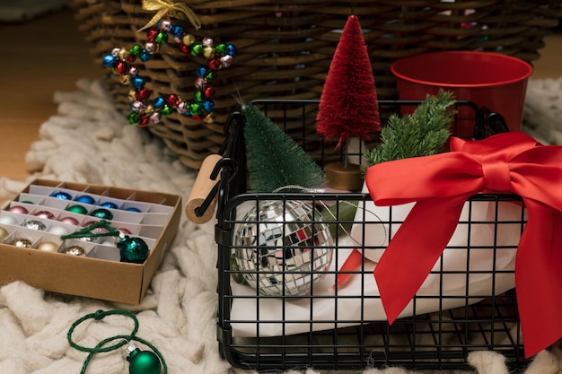 Kerstmis en Nieuwjaar rode en groene decoratie, snuisterij en ornament in een houten en draadmanden op de tapijtvloer.