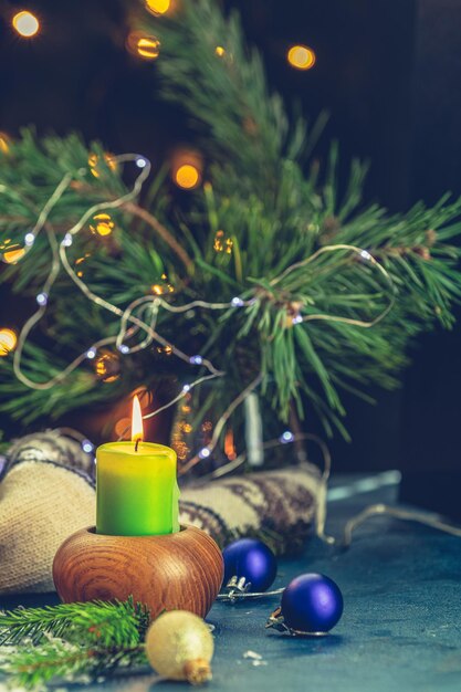 Kerstmis en Nieuwjaar samenstelling Kaarsen en vakantie decor takken van pijnbomen en sparren bokeh donkere achtergrond