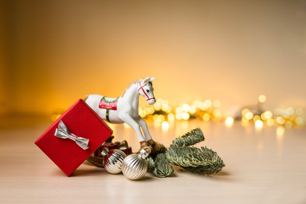 Kerstmis en Nieuwjaar samenstelling. Rode geschenkdoos met gouden gouden boke-verlichting, kerstversiering. Hoge kwaliteit foto