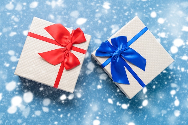 Kerstmis en Nieuwjaar wenskaart op blauw met geschenkdozen en confetti.
