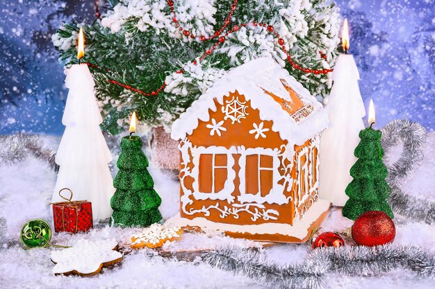 Foto kerstmis gemberbrood huis en gemberbroed koekjes met nieuwjaars decor op een besneeuwde achtergrond