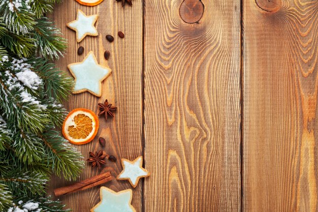 Kerstmis houten achtergrond met kruiden van de sneeuwspar en peperkoekkoekjes