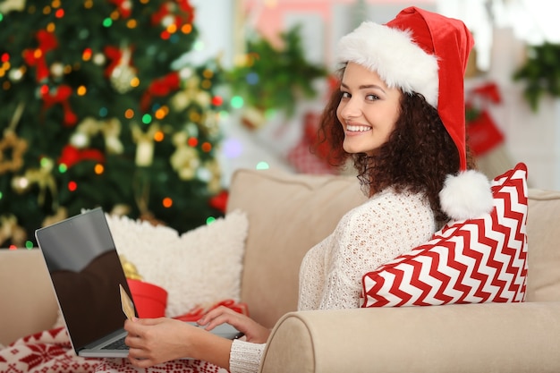 Kerstmis. Jonge vrouw die laptop met behulp van