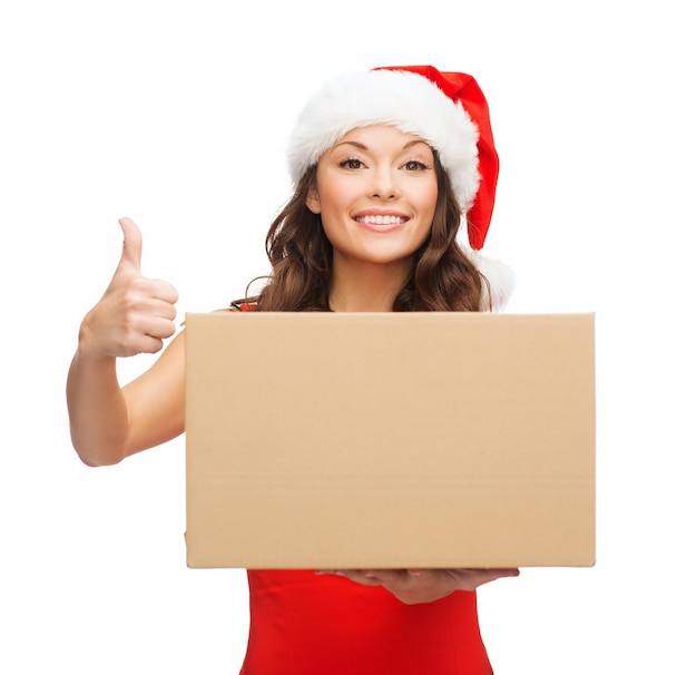 Kerstmis, kerst, winter, geluk concept - glimlachende vrouw in santa helper hoed met pakketdoos met duimen omhoog