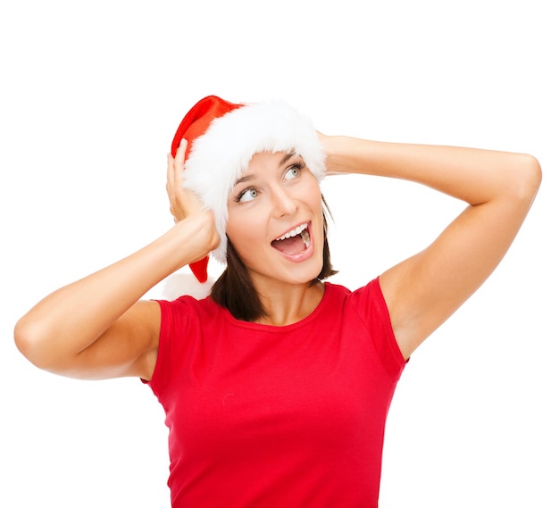 kerstmis, kerst, winter, geluksconcept - verraste vrouw in santa helper hat