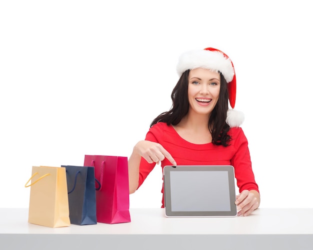 kerstmis, kerstmis, elektronica, gadgetconcept - glimlachende vrouw in santa helper hoed met leeg scherm tablet pc