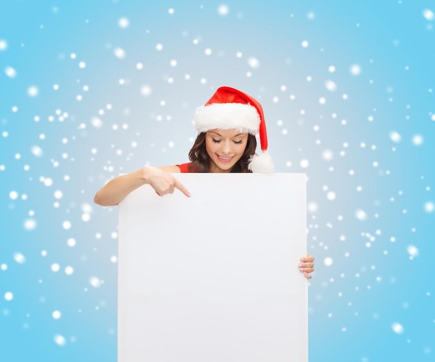 Kerstmis, Kerstmis, mensen, advertentie, verkoopconcept - gelukkige vrouw in santa helper hoed met leeg wit bord
