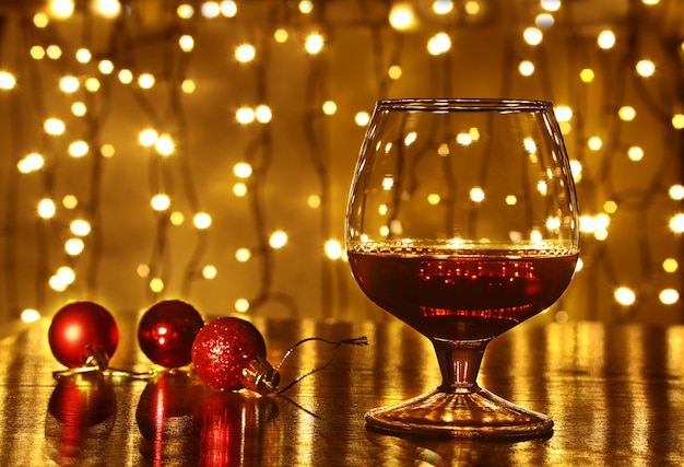 Kerstmis kleurrijke ballen en glas cognac of whisky met intreepupil lichten