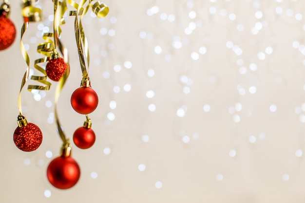 Kerstmis met hangende rode ballen en gouden lint op een mooie bokeh.