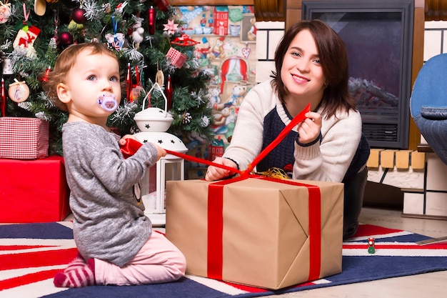 Kerstmis, moeder en dochter openen thuis cadeaus