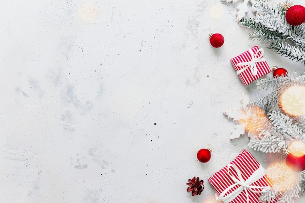 Kerstmis, nieuwjaar grijze betonnen plat leggen. rood wit gestreepte huidige geschenkdozen bovenaanzicht. cadeaulint en verpakkingspapier. kerstboomspar, kegels, speelgoedballen, houten ster. ruimtegebied op foto kopiëren