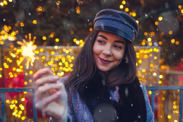 Kerstmis Nieuwjaar Vrouw brandende sterretje bij kerstboom op straatmarkt in de stad