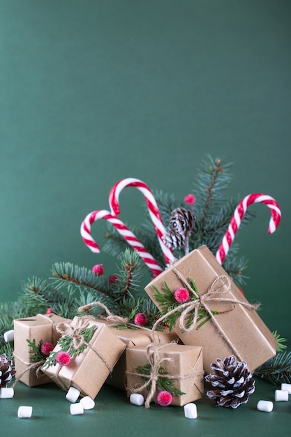 Kerstmis of nieuwjaarskaart. Beker met dennen, zuurstokken. Cadeaus verpakken in vintage beige ambachtelijk papier en natuurlijk decor.