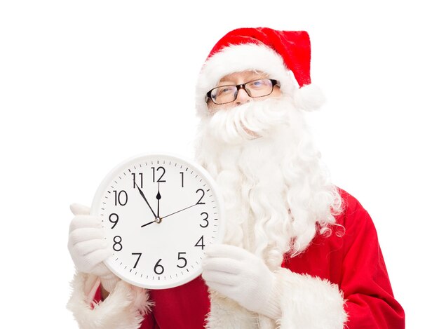 Kerstmis, vakantie en mensenconcept - man in kostuum van de kerstman met klok die twaalf toont