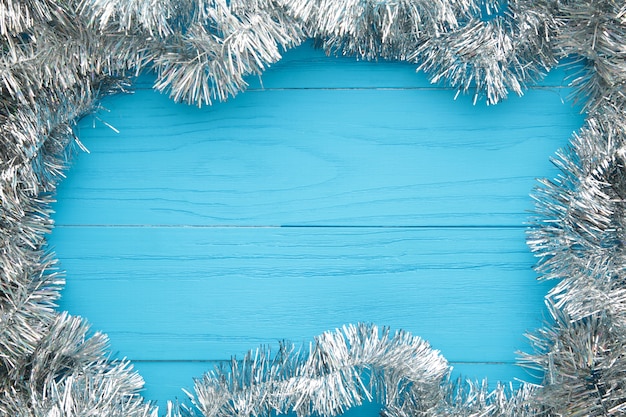 Kerstmis zilveren klatergoud op blauwe houten achtergrond. Dit heeft een uitknippad. Bovenaanzicht.