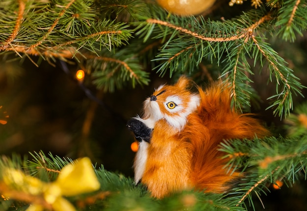 Kerstmisachtergrond met sparrentakken en stuk speelgoed eekhoorn op het