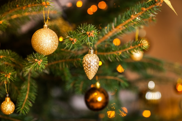 Kerstmisachtergrond met sparrentakken, Kerstmisdecoratie, en gouden glaskegel en gele en oranje ballen