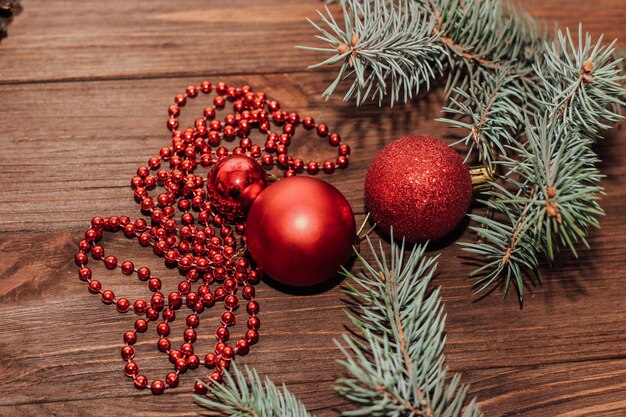 Kerstmisachtergrond met spartakje en rood speelgoed op houten planken.