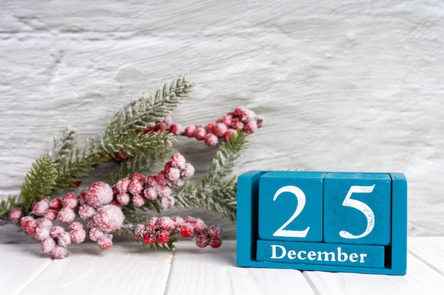 Kerstmisachtergrond met verfraaide dennenboom en blauwe eeuwigdurende kalender met datum