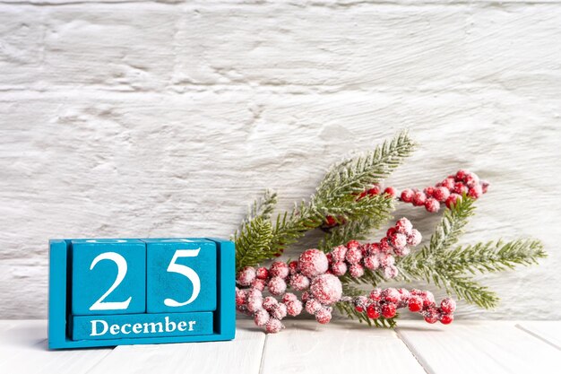 Kerstmisachtergrond met verfraaide dennenboom en blauwe eeuwigdurende kalender met datum