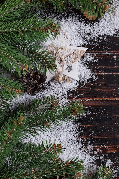 Kerstmisachtergrond, Sparren en kegels op een houten lijst, verpletterd door witte sneeuw, exemplaarruimte, hoogste mening.