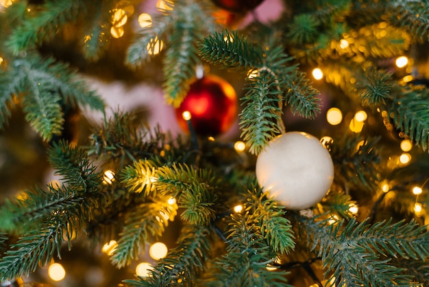 Kerstmisbal op de kerstboom met gloeiende lichten