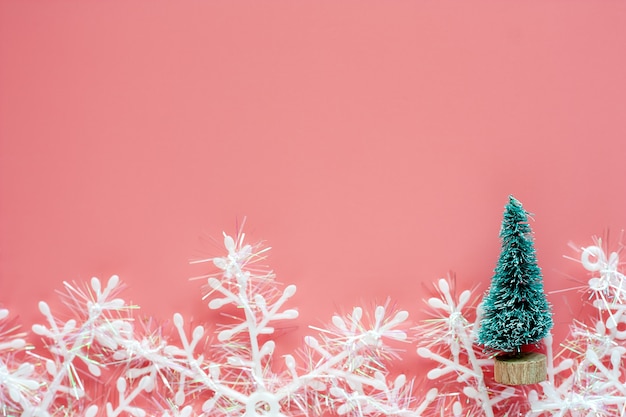 Kerstmisboom met sneeuwvlokornamenten op roze achtergrond voor kerstmisdag en vakantieconce