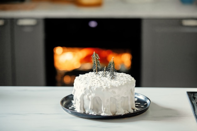 Kerstmiscake met slagroom op tafel in de keuken