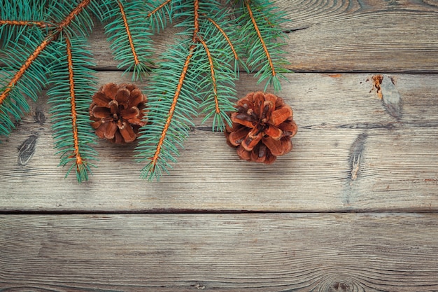 Kerstmisdecoratie met spar en denneappels op witte houten achtergrond