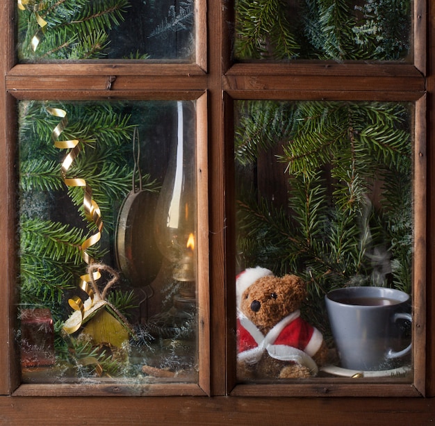 Kerstmisdecoratie met teddybeer in venster