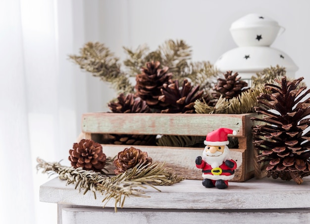 Kerstmisdecoratie van de Kerstman en denneappels op houten kabinet