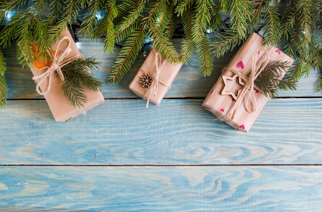 Kerstmisgiften op een witte houten achtergrond met boomtakken.