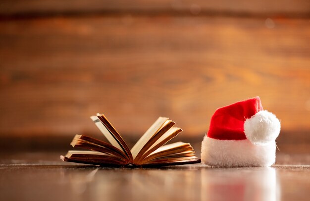 Kerstmishoed en open boek op houten lijst