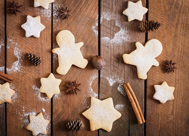 Kerstmiskoekjes en klatergoud op een houten lijst