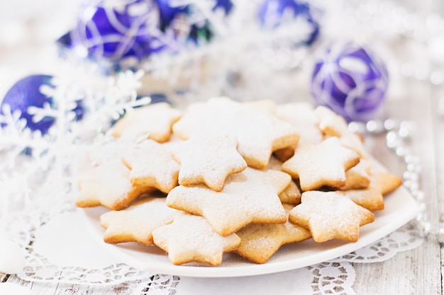 Kerstmiskoekjes en klatergoud op een houten lijst