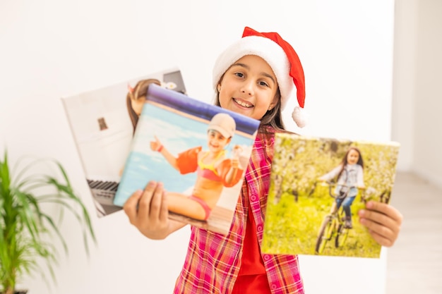 Kerstmismeisje dat zich met foto's op canvas bevindt dat op wit wordt geïsoleerd