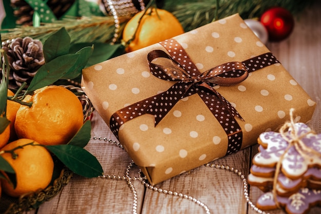 Kerstmissamenstelling huidige doos en peperkoekkoekje, anijsplant en kaneel op houten lijst.