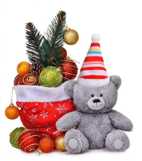 Kerstmissamenstelling met de zakhoogtepunt van de kerstman van speelgoed en glimlachende teddybeer