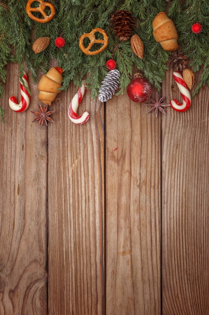 Kerstmissamenstelling van boomtakken, suikergoed en decoratie op houten achtergrond. Bovenaanzicht Kopieer ruimte.