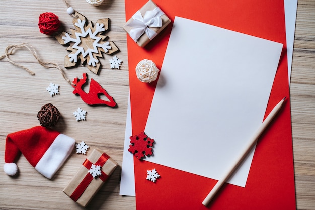 Kerstmissamenstelling van dennenboomversieringen en geschenkdozen met blanco vel papier