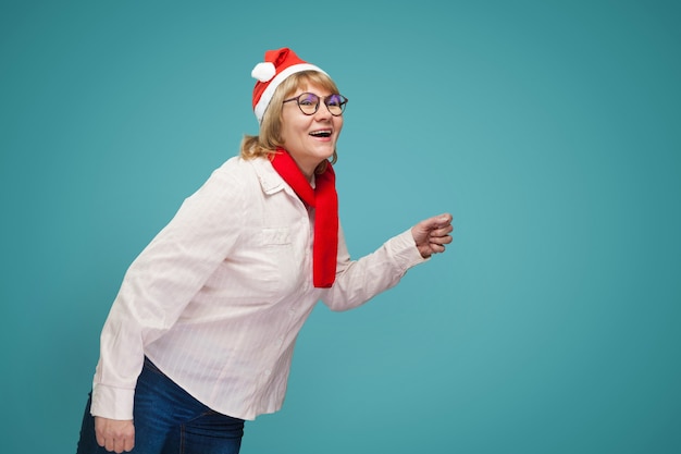 Kerstmisvrouw in overhemd en jeans op blauwe achtergrond