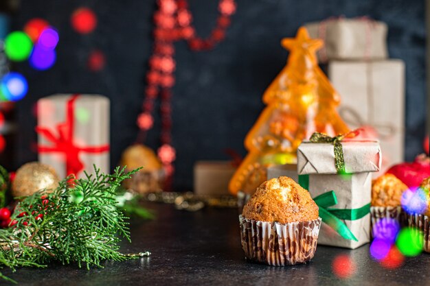 kerstmuffins met decoraties op zwarte tafel