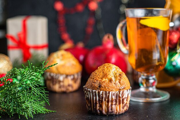 kerstmuffins met decoraties op zwarte tafel