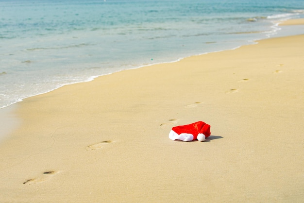 Kerstmuts op de zee. Kerst- en nieuwjaarsvakantie in warme landen.