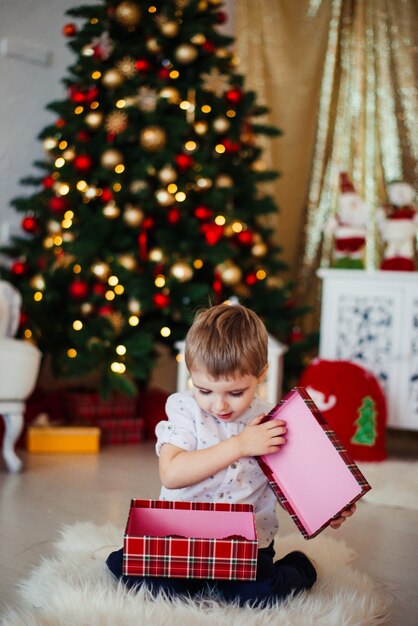 Kerstochtend jongen pakt cadeautjes uit