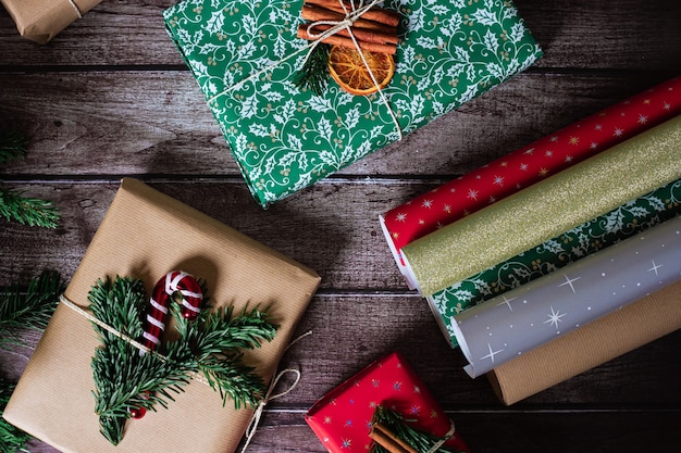 Foto kerstpakketdozen met kraft, rode, groene decoratie en kleurrijke papierrollen