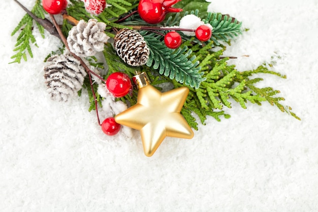 Kerstrand met kerstdecor, groene spartakje en glazen bollen op witte sneeuwachtergrond