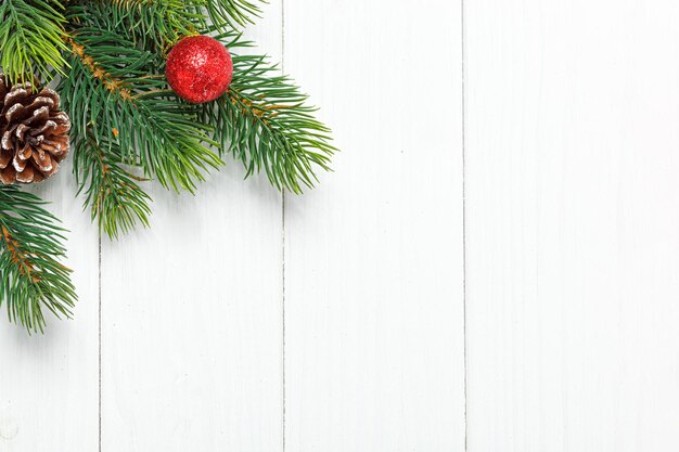 Kerstsamenstelling Kerstboomtak met speelgoedkegels op een houten achtergrond