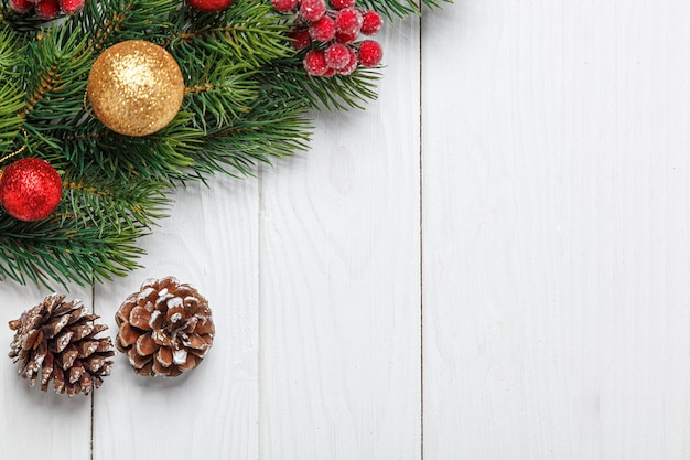 Kerstsamenstelling Kerstboomtak met speelgoedkegels op een houten achtergrond